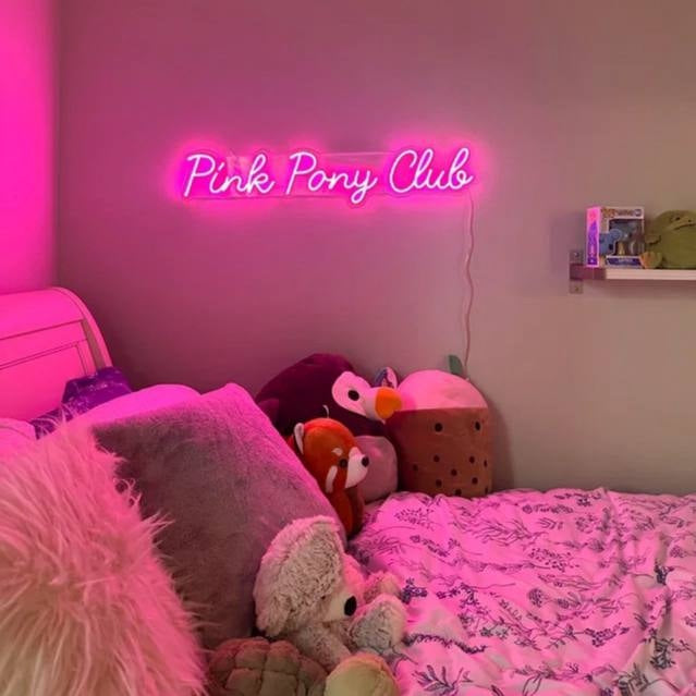 bright hot pink neon sign mounted in a modern girls bedroom