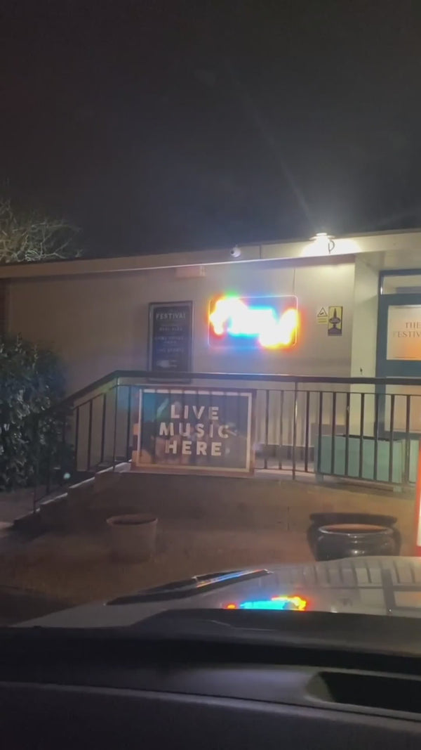 outdoor pub neon sign installation at The Festival Coventry UK LED neon branding exterior hospitality venue night visibility green wall backdrop
